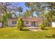 Lush backyard featuring mature trees and patio area at 741 Greenway Pl, Daytona Beach, FL 32114