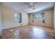 Bedroom with ceiling fan, wood floors, and two windows; neutral paint at 741 Greenway Pl, Daytona Beach, FL 32114