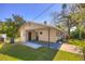 Exterior elevation featuring a carport, well-maintained lawn, and mature trees at 741 Greenway Pl, Daytona Beach, FL 32114