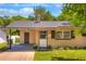 Inviting single-story home featuring a cozy front porch and well-maintained landscaping at 741 Greenway Pl, Daytona Beach, FL 32114