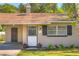 Close-up of a charming home's front entrance, showing door, shutters, and manicured lawn at 741 Greenway Pl, Daytona Beach, FL 32114