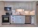 Well-lit kitchen features white cabinets, stainless steel appliances, and tile backsplash at 741 Greenway Pl, Daytona Beach, FL 32114