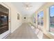 Large, sunny Florida room featuring tile floors, windows and ceiling fans at 826 W Gaucho Cir, Deltona, FL 32725