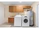 Well-lit laundry room with washer, dryer, and overhead cabinets for storage at 826 W Gaucho Cir, Deltona, FL 32725