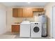 Functional laundry area equipped with a washer, dryer, sink, water heater and overhead cabinets for storage at 826 W Gaucho Cir, Deltona, FL 32725