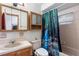 Modest bathroom featuring a single sink vanity, medicine cabinet, and a shower/tub combo with decorative curtain at 980 Buttercup Ter, Deltona, FL 32725