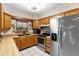 Traditional eat-in kitchen features wooden cabinets, tile floors, and stainless steel appliances at 980 Buttercup Ter, Deltona, FL 32725