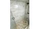 A newly remodeled shower with glass doors, a pebble floor, and stylish tile walls at 1000 Lake Of The Woods Blvd # 104F, Casselberry, FL 32730