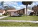 Charming single-story home featuring a well-manicured lawn and attractive exterior elevation with stone accents and terracotta-colored roof at 10477 Montpelier Cir, Orlando, FL 32821