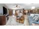 Spacious living room with stylish furnishings, a large rug, a ceiling fan, and an open layout with a view to the kitchen at 10477 Montpelier Cir, Orlando, FL 32821