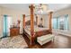 Spacious primary bedroom featuring a four-poster bed, ceiling fan, and natural light from the windows at 1051 Dunbar Ave, Sanford, FL 32771