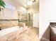 A tiled tub and shower in a brightly lit bathroom with a decorative mosaic accent at 1226 Deer Lake Cir, Apopka, FL 32712
