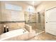 An elegant, tiled bathtub and shower stall feature eye-catching mosaic accents at 1226 Deer Lake Cir, Apopka, FL 32712