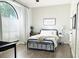 Bright bedroom with large window, wood floors, and a modern black metal bed frame at 1226 Deer Lake Cir, Apopka, FL 32712