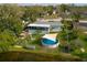 Aerial view of the backyard featuring a pool, screened porch, lush greenery and waterfront access, offering a private oasis at 1258 Russell Dr, Ocoee, FL 34761