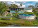 Large, grassy backyard featuring a pool, screened patio, fire pit, and lake view at 1258 Russell Dr, Ocoee, FL 34761