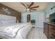 Bedroom features a large bed, wood accent wall, ceiling fan, and access to the ensuite bathroom at 1258 Russell Dr, Ocoee, FL 34761