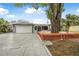 Charming single-story home with a two-car garage, light gray exterior paint and a deck in the front yard at 1259 Vanderbilt Dr, Ormond Beach, FL 32174