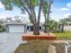 Charming single-story home with a two-car garage, light gray exterior paint and a deck in the front yard at 1259 Vanderbilt Dr, Ormond Beach, FL 32174