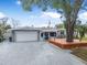 Charming single Gathering home with a two-car garage, and mature tree with deck in daytime at 1259 Vanderbilt Dr, Ormond Beach, FL 32174