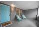 Inviting covered front porch with two chairs and a brightly colored door at 1259 Vanderbilt Dr, Ormond Beach, FL 32174