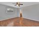 Bedroom with wood floors, ceiling fan, and a view into the ensuite bathroom at 129 S Marydell Ave, Deland, FL 32720