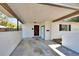 Carport area featuring a white exterior with black trim and a vibrant red front door at 129 S Marydell Ave, Deland, FL 32720