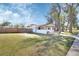 Side exterior with a fenced yard, front porch, and mature trees, creating a welcoming atmosphere at 129 S Marydell Ave, Deland, FL 32720