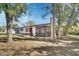 Charming single-story home with a bright red front door, screened porch, carport, and mature trees on the property at 129 S Marydell Ave, Deland, FL 32720