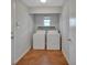 Functional laundry room with terracotta tile, washer, dryer, and built in shelving at 129 S Marydell Ave, Deland, FL 32720