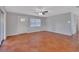 Bright living room with terracotta tile, a ceiling fan, and natural light streaming through the windows at 129 S Marydell Ave, Deland, FL 32720