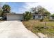 Charming single-story home with a wide driveway, a two car garage and tropical landscaping at 1341 Imperial Dr, Daytona Beach, FL 32117