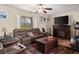 Cozy living room with a fireplace, leather seating, and natural light from the window at 1424 Breaks Way, Port Orange, FL 32127