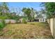 Wide view of the backyard features a storage shed, mature trees, and plenty of space for outdoor activities at 1702 Carolina Ave, Ormond Beach, FL 32174