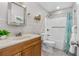 Well-lit bathroom featuring a vanity, toilet, shower with grab bar, and decorative accents at 1702 Carolina Ave, Ormond Beach, FL 32174