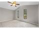 Bright bedroom features vaulted ceilings, tile flooring, a ceiling fan, and two windows that provide natural light at 1702 Carolina Ave, Ormond Beach, FL 32174