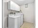 Functional laundry room equipped with a washing machine, dryer, and overhead storage cabinets at 1702 Carolina Ave, Ormond Beach, FL 32174