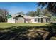 Rear exterior featuring a patio seating area and a screened-in porch with green accents at 1773 Blue Oak Ct, Deland, FL 32720