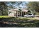 Exterior view of the house featuring a screened-in porch, a well-manicured lawn, and a vehicle parked in the driveway at 1773 Blue Oak Ct, Deland, FL 32720