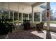 Relaxing screened-in porch with wicker furniture, floral decorations, and an outdoor view, offering a great relaxation area at 1773 Blue Oak Ct, Deland, FL 32720