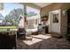 Inviting screened porch with wicker furniture and a view of the outdoor scenery of the surrounding landscape at 1773 Blue Oak Ct, Deland, FL 32720