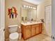 Bathroom with decorative toucans, wood cabinet, and a toilet at 1875 Glenwood Oaks Ln, Deland, FL 32720