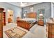 Comfortable bedroom featuring a wood bed frame, ceiling fan and a view to the attached bathroom at 1875 Glenwood Oaks Ln, Deland, FL 32720