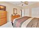 Bedroom features a ceiling fan, dresser, and a bed with a patterned comforter at 1875 Glenwood Oaks Ln, Deland, FL 32720