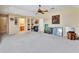 Large carpeted bonus room with ceiling fan and built-in shelving niche leading to a bathroom at 1875 Glenwood Oaks Ln, Deland, FL 32720
