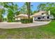 Exterior view of the home and garage with lush landscaping and an RV at 1875 Glenwood Oaks Ln, Deland, FL 32720