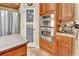 Gourmet kitchen with stainless steel appliances including double ovens, pantry door and wood cabinetry at 1875 Glenwood Oaks Ln, Deland, FL 32720