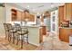 Kitchen features an island with bar stool seating, stainless steel fridge and wood cabinetry at 1875 Glenwood Oaks Ln, Deland, FL 32720