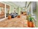 Bright living room with green walls, tiled floor, wet bar, and access to outdoor spaces through French doors at 1875 Glenwood Oaks Ln, Deland, FL 32720
