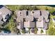 Overhead view of townhomes with lush greenery, a pond, and ample parking at 2015 Cornell Pl, Port Orange, FL 32128